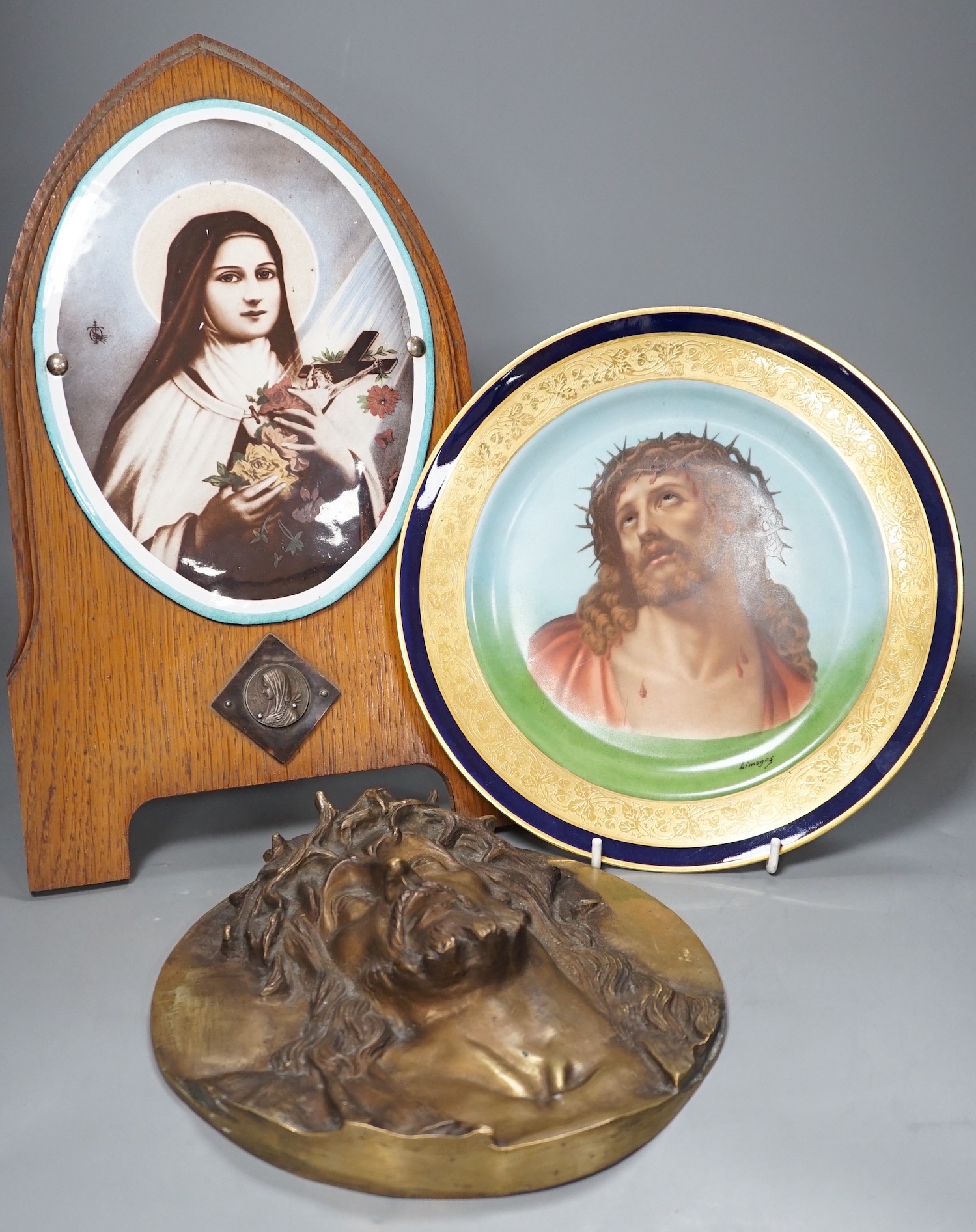 A Limoges plate and cast bronze portrait of Christ with crown of thorns and a framed plaque of the Madonna, frame 37 cms high